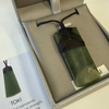 Green stone pounamu jade pendant with black cord in a box, accompanied by a card explaining its meaning.